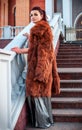 Fashion outdoor photo of glamour woman with dark hair wearing luxurious fur coat and leather gloves Royalty Free Stock Photo