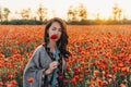 Pretty woman with red poppy in flower meadow. Royalty Free Stock Photo