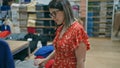 Fashion passion! beautiful hispanic woman with glasses choosing chic clothes in a retail store Royalty Free Stock Photo