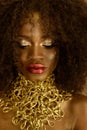 Fashion photo of beautiful elegant african american woman. Girl posing with closed eyes and jewelry, wearing fashionable gold neck Royalty Free Stock Photo