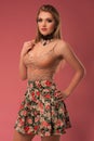 Fashion photo of a beautiful young woman in a pretty clothes with flowers posing on the pink background. Fashion photo Royalty Free Stock Photo