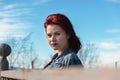 Fashion photo of female red hair model wear blue denim jacket and red dress. outdoors. High fashion.