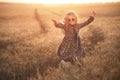 Fashion photo of a little girl in leopardprint dress, sunglasses and straw hat at the evening wheat field Royalty Free Stock Photo