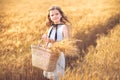 Fashion photo of a little girl in white dress and straw hat at the evening wheat field Royalty Free Stock Photo