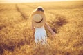 Fashion photo of a little girl in white dress and straw hat at the evening wheat field Royalty Free Stock Photo