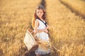 Fashion photo of a little girl in white dress and straw hat at the evening wheat field Royalty Free Stock Photo