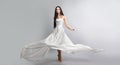 fashion photo of young girl in white dress flying tissue. Lightweight material.