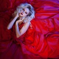 Fashion photo of young magnificent woman in red dress. Studio portrait Royalty Free Stock Photo