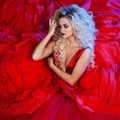 Fashion photo of young magnificent woman in red dress. Studio portrait Royalty Free Stock Photo