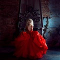 Fashion photo of young magnificent woman. Running towards camera. Seductive blonde in red dress with fluffy skirt Royalty Free Stock Photo