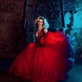 Fashion photo of young magnificent woman. Running towards camera. Seductive blonde in red dress with fluffy skirt Royalty Free Stock Photo