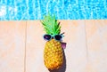 Fashion pineapple and sunglasses on a blue water pool Royalty Free Stock Photo