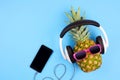 Fashion pineapple with sunglasses and headphones over blue