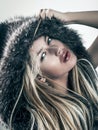 Fashion portrait of attractive blonde woman in fur coat hood Royalty Free Stock Photo