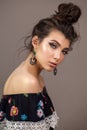 Fashion portrait of a beautiful brunette girl with blue eyes, professional makeup, perfect skin and ethnical accessories