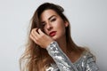 Fashion portrait of a beautiful smiling woman with long hair in a pretty silver dress with tinsel over empty light Royalty Free Stock Photo