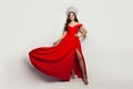 Fashion portrait of beautiful woman wearing red blowing dress and diamond crown on white background Royalty Free Stock Photo