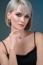 Fashion portrait of a beautiful young woman in stylish. Stylish hairstyle and light makeup. Wearing earring and finger ring. Royalty Free Stock Photo