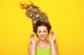 Fashion portrait of cheerful girl on colored background with kiwi slices on long hair, people and food, young funny woman head Royalty Free Stock Photo