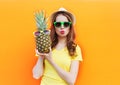 Fashion portrait cool girl in sunglasses with pineapple over colorful orange Royalty Free Stock Photo