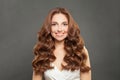 Fashion portrait of cute brunette woman with long and shiny wavy hair smiling. Stylish model with brown curly hairstyle Royalty Free Stock Photo