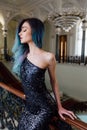 Fashion portrait of gorgeous girl with blue dyed hair long. The beautiful evening cocktail dress.