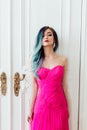 Fashion portrait of gorgeous girl with blue dyed hair long. The beautiful evening cocktail dress. Royalty Free Stock Photo