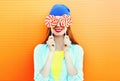 Fashion portrait happy smiling woman and lollipop is having fun over colorful orange Royalty Free Stock Photo