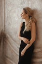 Fashion portrait of a model girl wearing trendy black dress posing in a minimalist beige interior Royalty Free Stock Photo