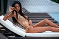 Young asian sexy girl in a beige bikini posing at hotel territory Royalty Free Stock Photo