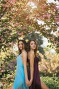Fashion Portrait Photo of Two Women Near Blossoming Tree on Nature