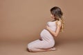 Fashion portrait pregnant woman blonde, perfect figure of girl. Woman is waiting for birth of a baby. Art woman in late pregnancy