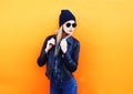 Fashion portrait pretty blonde woman posing in rock black style on colorful orange background Royalty Free Stock Photo