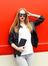 Fashion portrait pretty blonde woman wearing a rock black leather jacket, sunglasses and handbag clutch Royalty Free Stock Photo