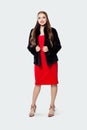 Fashion portrait of pretty model woman in black coat and red dress on white background Royalty Free Stock Photo