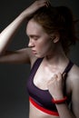 Fashion portrait in profile of a young girl in a sports top on a dark background Royalty Free Stock Photo