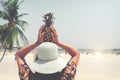 Fashion portrait rear of beautiful woman with fresh pineapple holds up - vacation on tropical beach in summer