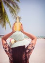 Fashion portrait rear of beautiful women with fresh pineapple holds up - vacation on tropical beach in summer
