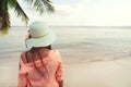 Fashion portrait rear of happy young beautiful woman to wear straw hat - stand on the beach in summer. Royalty Free Stock Photo