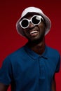 Fashion portrait of smiling man in hat and sunglasses at studio Royalty Free Stock Photo