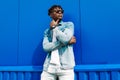 Fashion portrait stylish dark-skinned man, dressed in a jacket and jeans. Fashionable man posing against blue wall Royalty Free Stock Photo