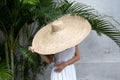 Fashion portrait of stylish woman wearing white dress and large big giant straw