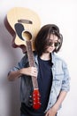 Fashion portrait of a teenager playing guitar in studio wearing jeans jacket. Royalty Free Stock Photo