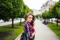 Fashion portrait trendy young woman with backpack in the city simmer