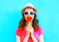 Fashion portrait woman kissing red lollipop shape of a heart over colorful Royalty Free Stock Photo