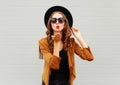 Fashion portrait woman model blowing red lips sends air sweet kiss wearing black hat, sunglasses over urban grey Royalty Free Stock Photo