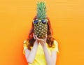 Fashion portrait woman and pineapple with sunglasses over colorful orange Royalty Free Stock Photo