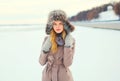 Fashion portrait woman wearing a coat jacket and hat over snow in winter Royalty Free Stock Photo