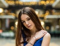 Fashion portrait of an 18 year old red haired pretty girl sitting legs crossed in a short blue dress Royalty Free Stock Photo