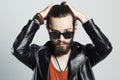 Fashion Portrait of young bearded man in leather jacket. Hipster in sunglasses Royalty Free Stock Photo